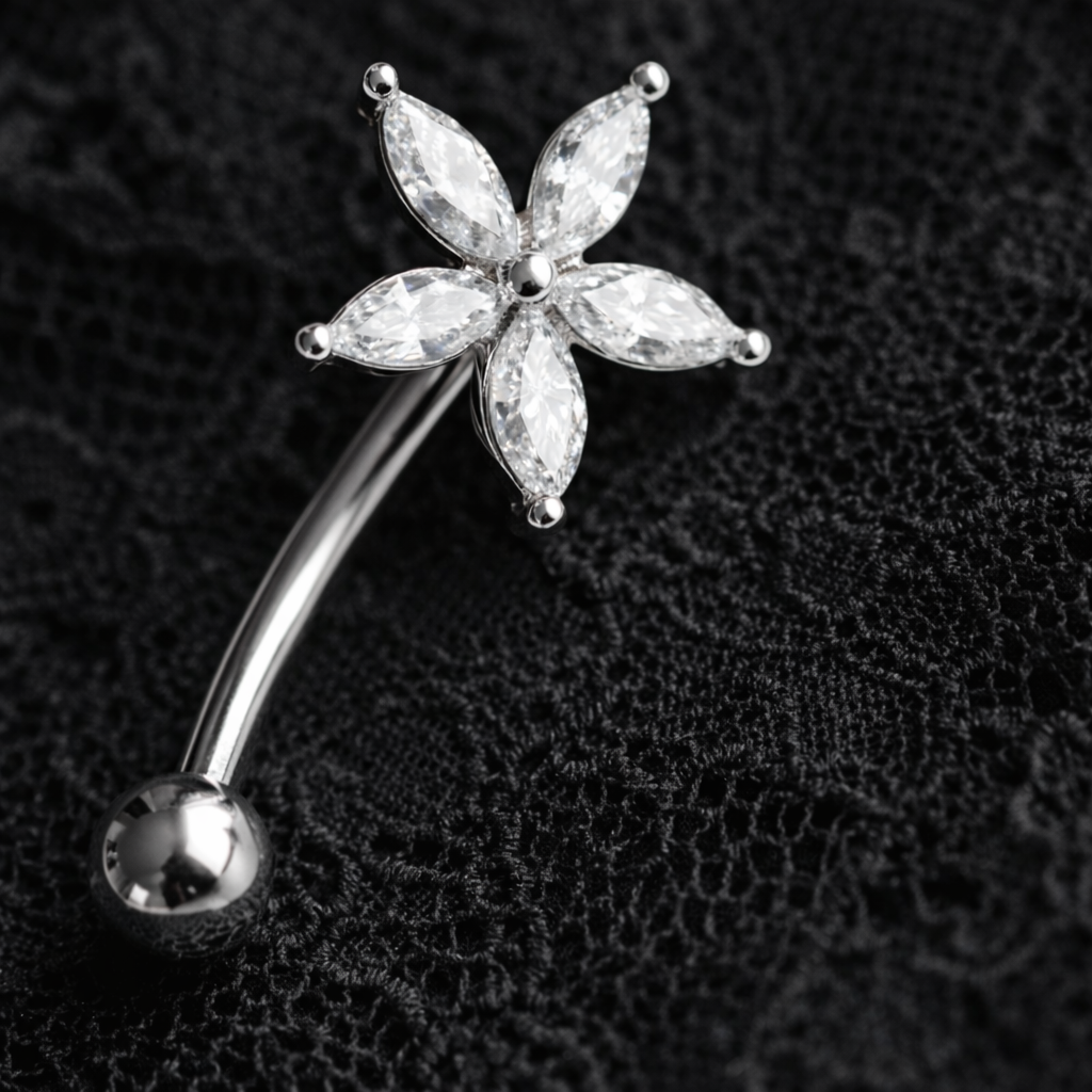 Silver eyebrow/rook barbell with a star-shaped gemstone on a black textured background