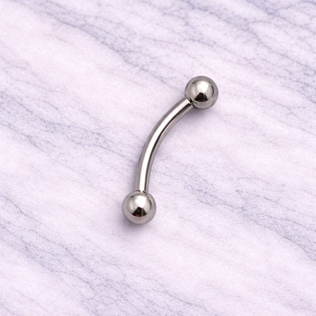 Silver eyebrow/rook curved barbell on a marble background