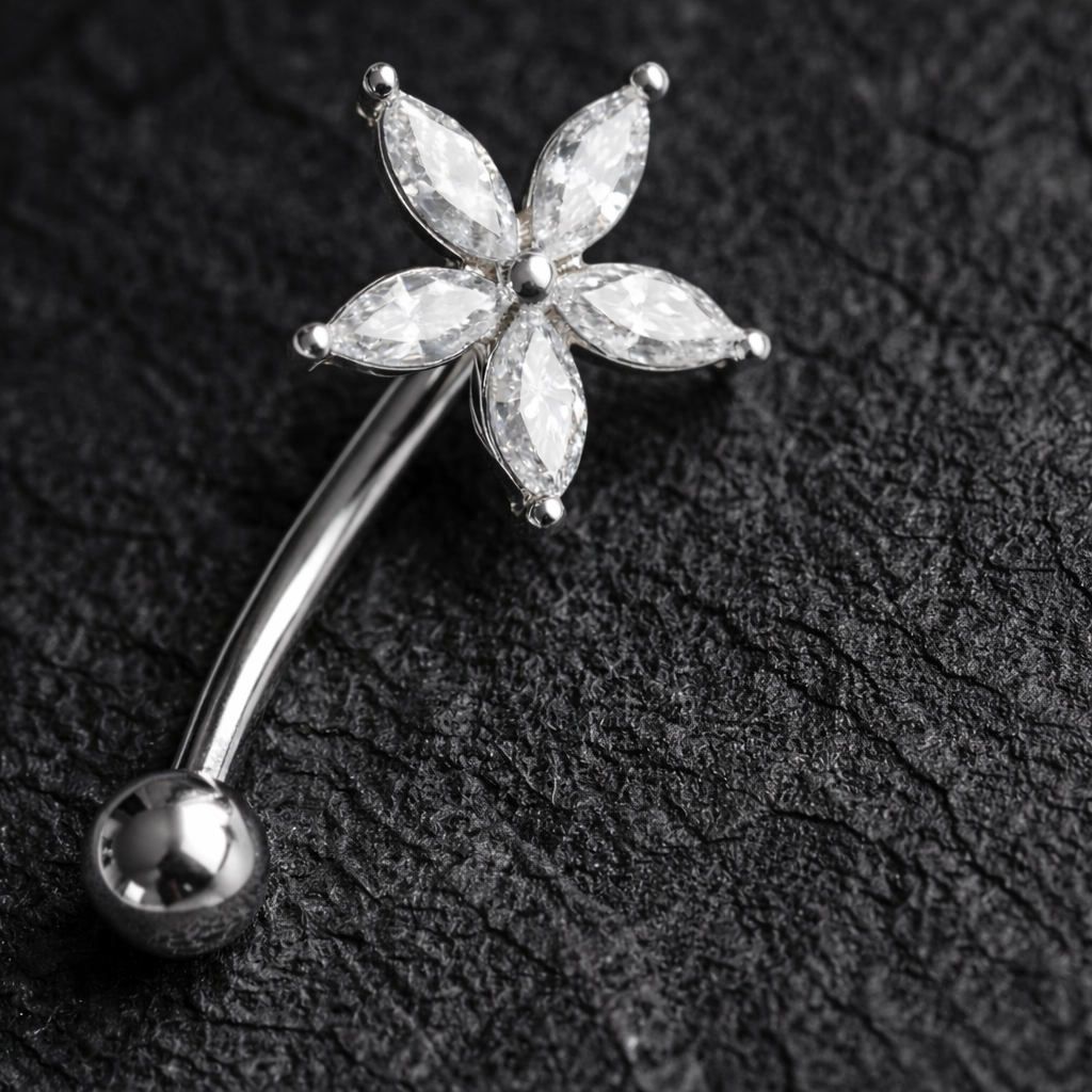 Silver eyebrow/rook piercing bar with a floral design on a dark textured background