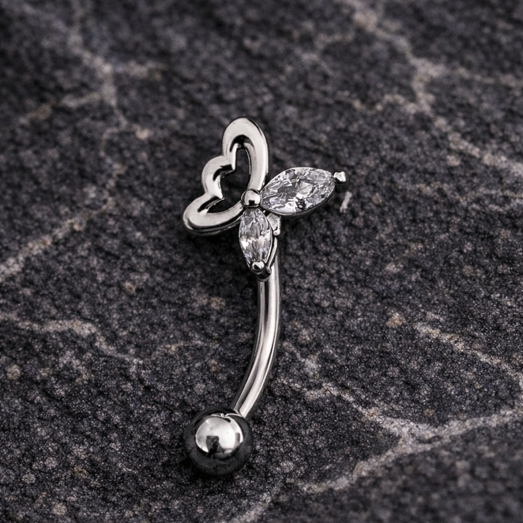 Silver eyebrow/rook piercing bar with butterfly design on a dark stone surface