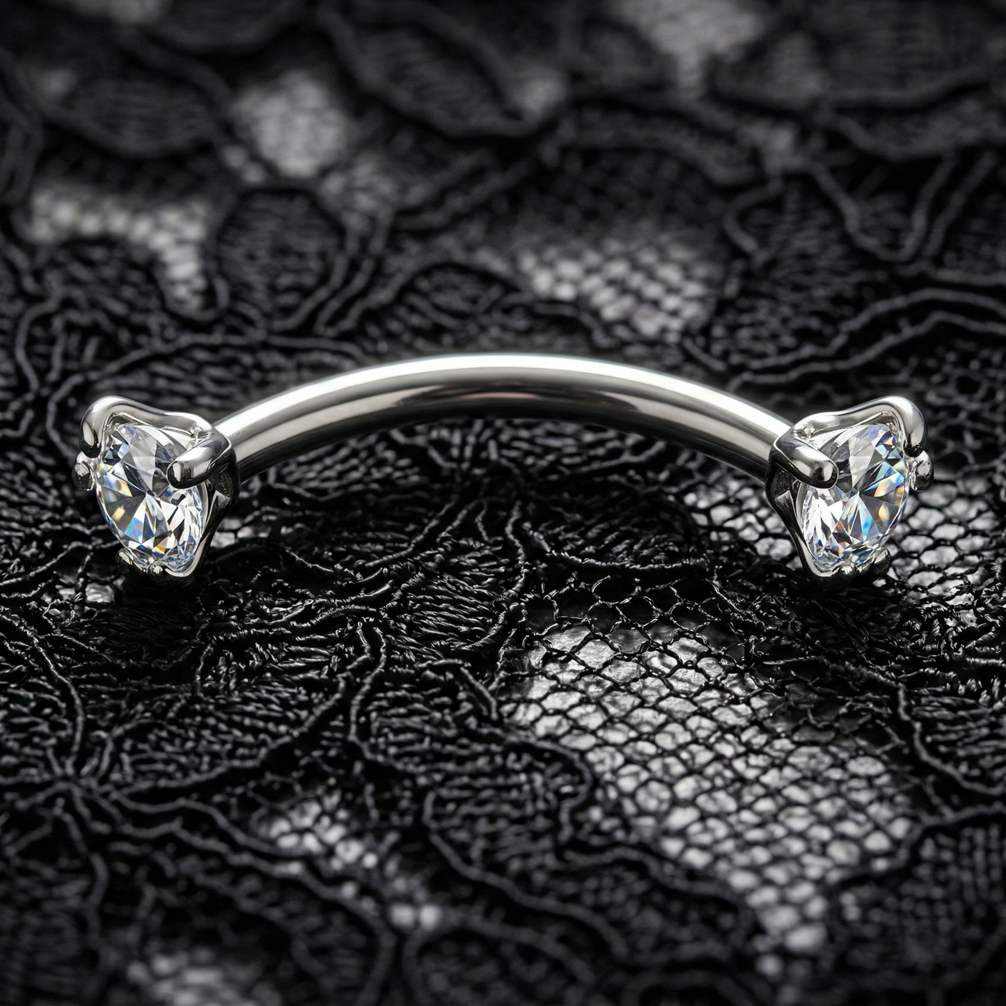 Silver eyebrow/rook piercing bar with clear gemstones on a black lace background