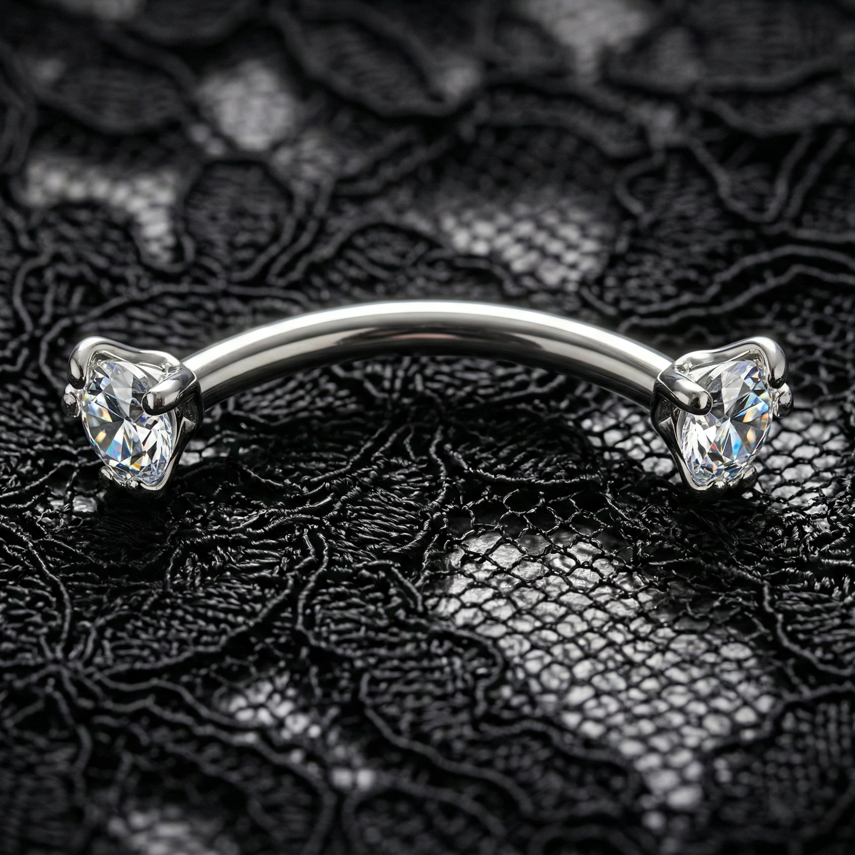 Silver eyebrow/rook piercing bar with clear gemstones on a black lace background