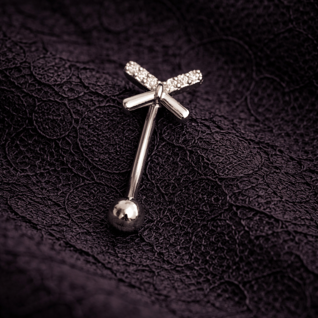 Silver eyebrow/rook piercing ring with a ball on a dark textured fabric background