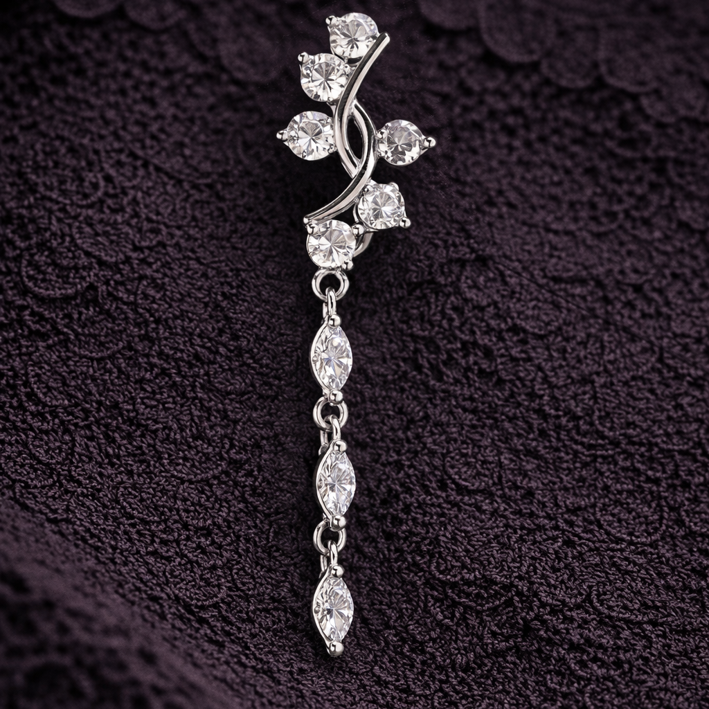 Silver floral brooch with clear stones on a textured dark background