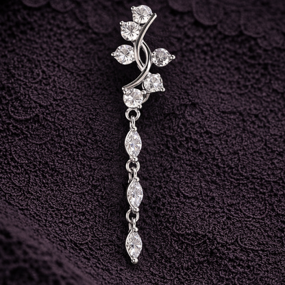 Silver floral brooch with clear stones on a textured dark background