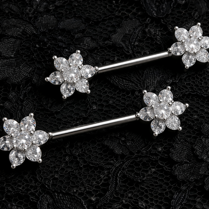 Silver floral nipple barbells on a black lace background