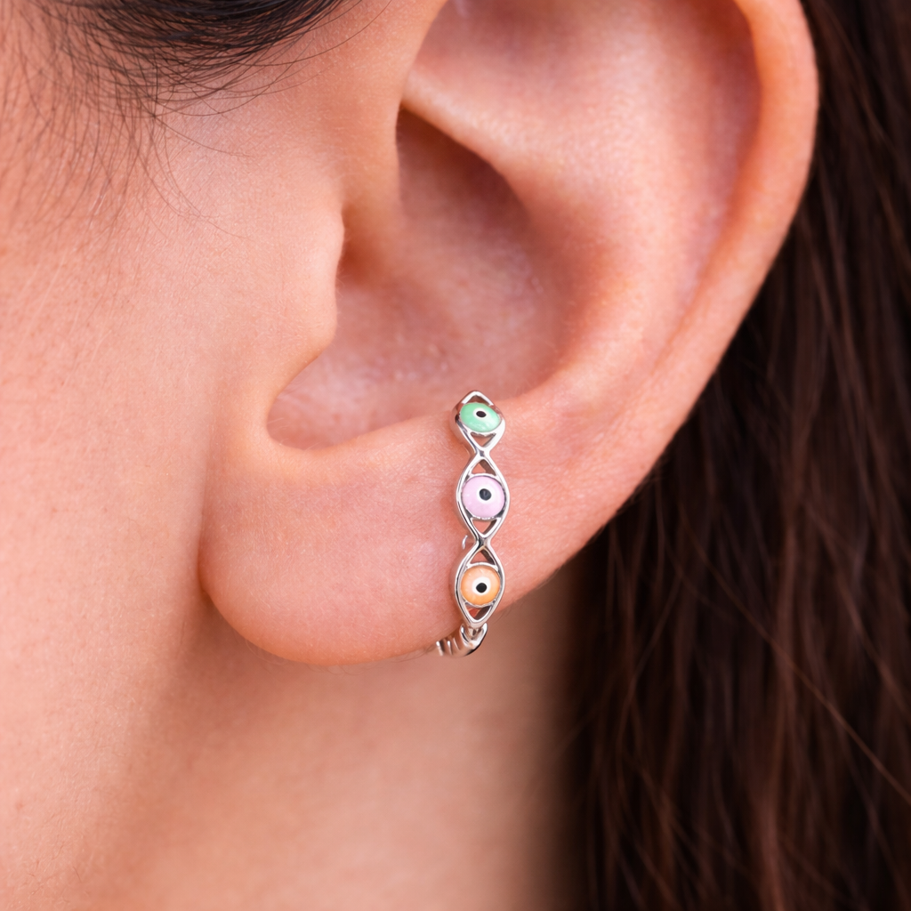 Close-up of an ear wearing a colorful earring with a blurred background