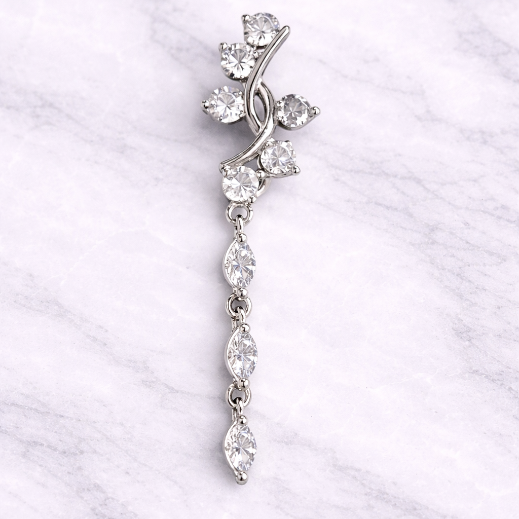 Silver navel ring with clear stones on a white marble background