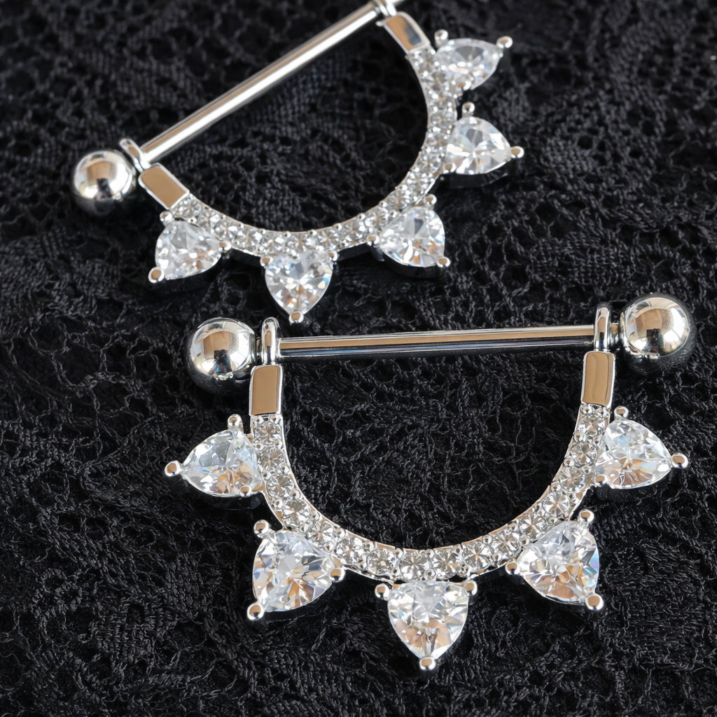 Silver nipple bar with clear gemstones on a black lace background