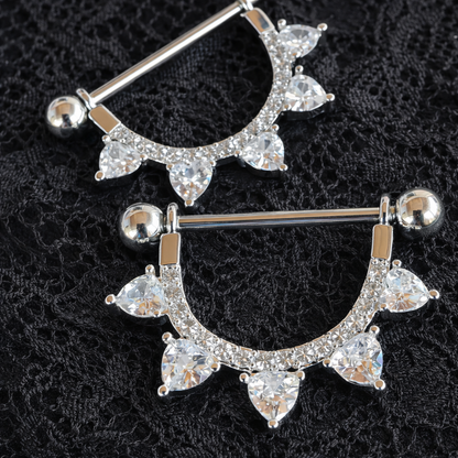Silver nipple bar with clear gemstones on a black lace background