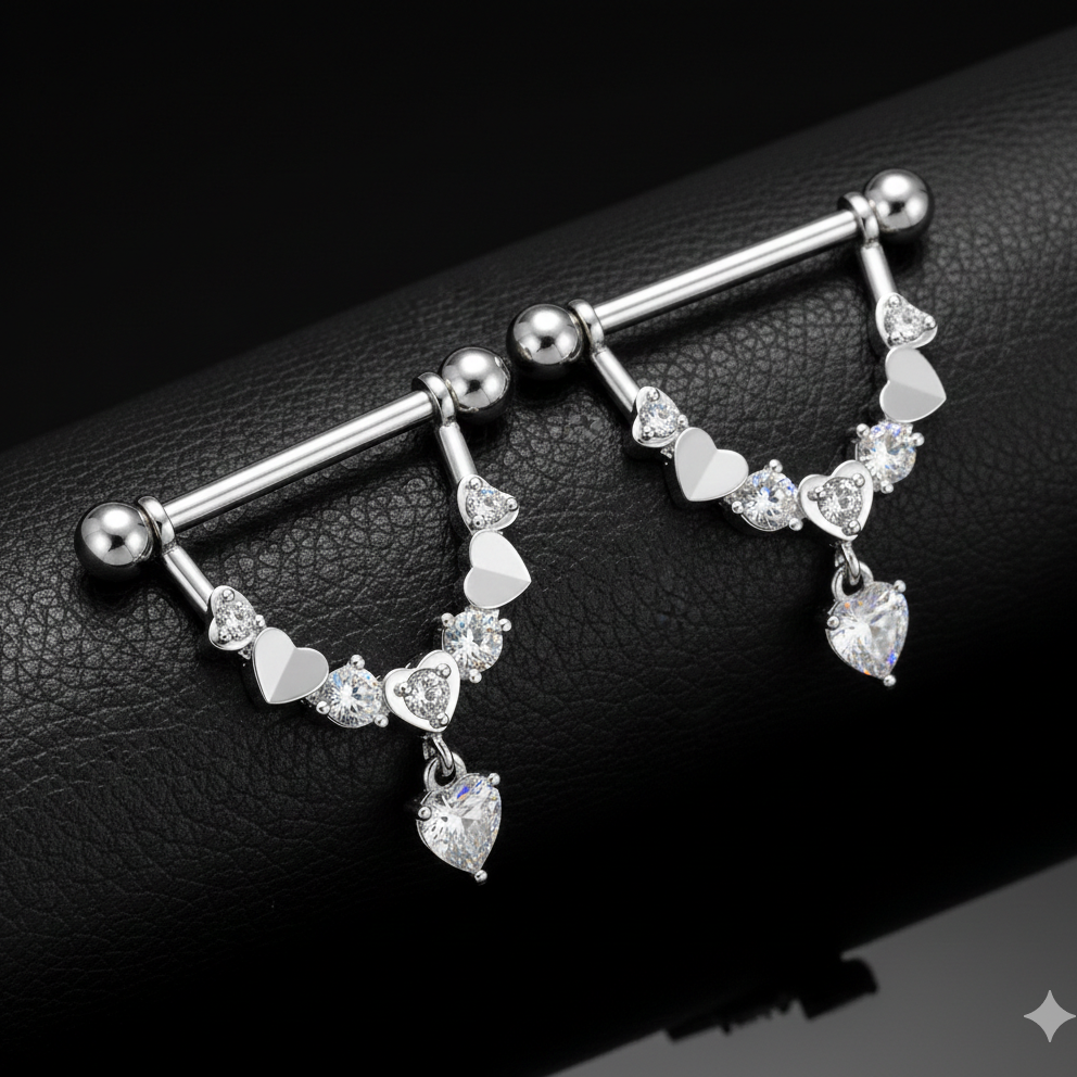 Silver nipple bars with heart-shaped charms on a black leather surface
