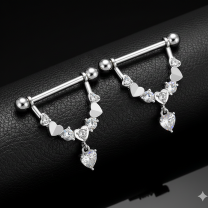 Silver nipple bars with heart-shaped charms on a black leather surface