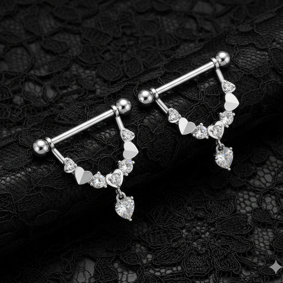 Silver nipple bars with heart-shaped gemstones on a black lace background