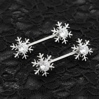 Silver snowflake-shaped nipple bars on a black lace background