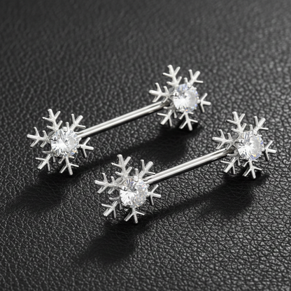 Silver snowflake shaped nipple bars on a dark textured surface