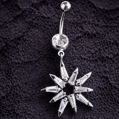 Silver belly button ring with a star-shaped pendant on a textured black background