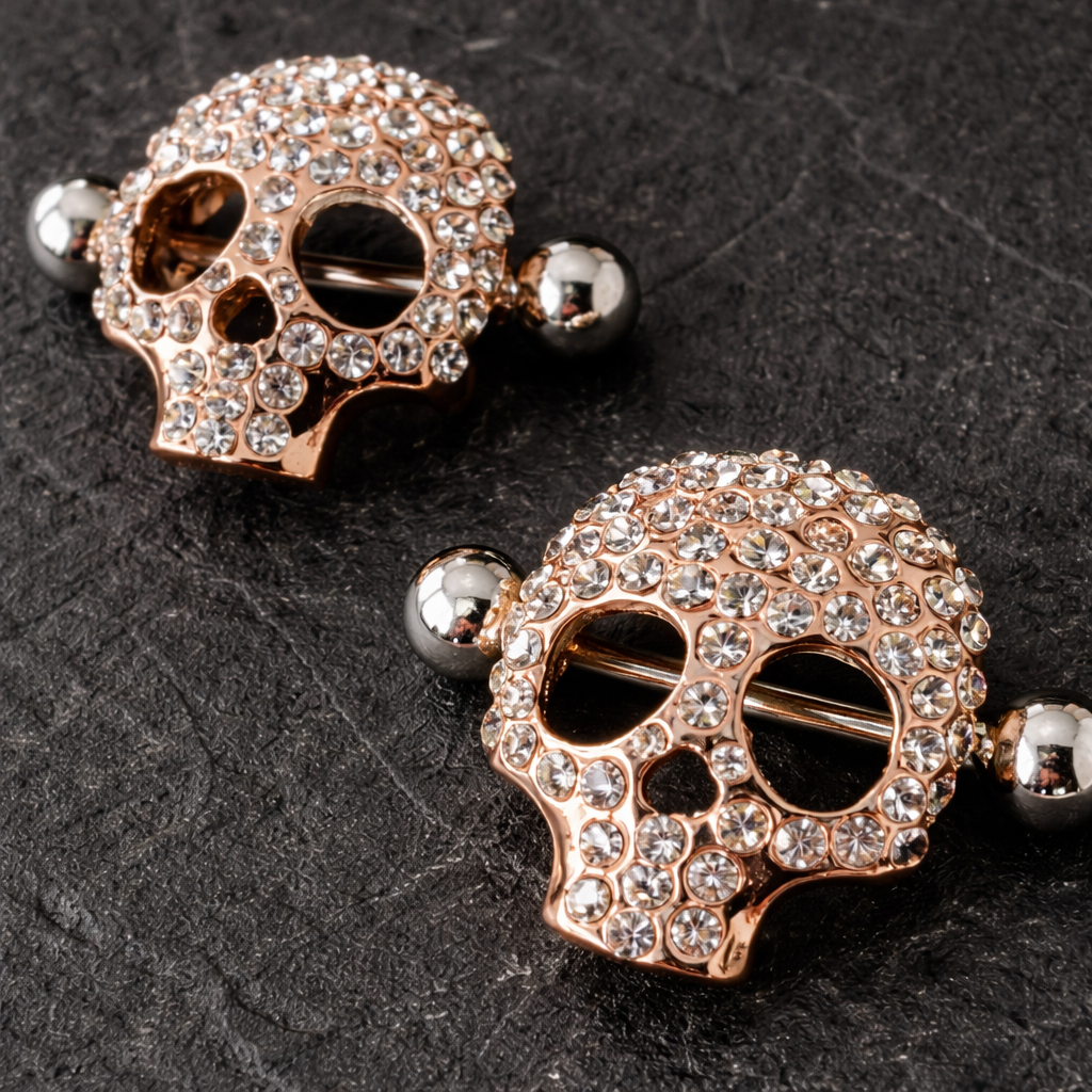 Skull-shaped nipple bars with rhinestones on a dark textured background
