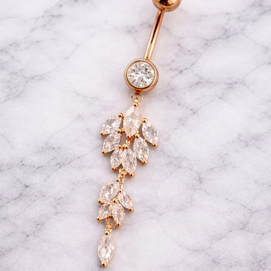 Rose gold belly button ring with crystal stones on a marble background