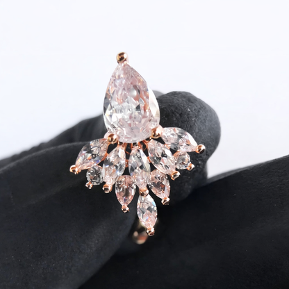 Rose gold ring with large central diamond and smaller marquise-shaped diamonds on a black stand.