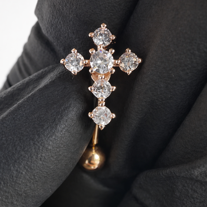 Rose Gold cross-shaped brooch with clear gemstones on a black background