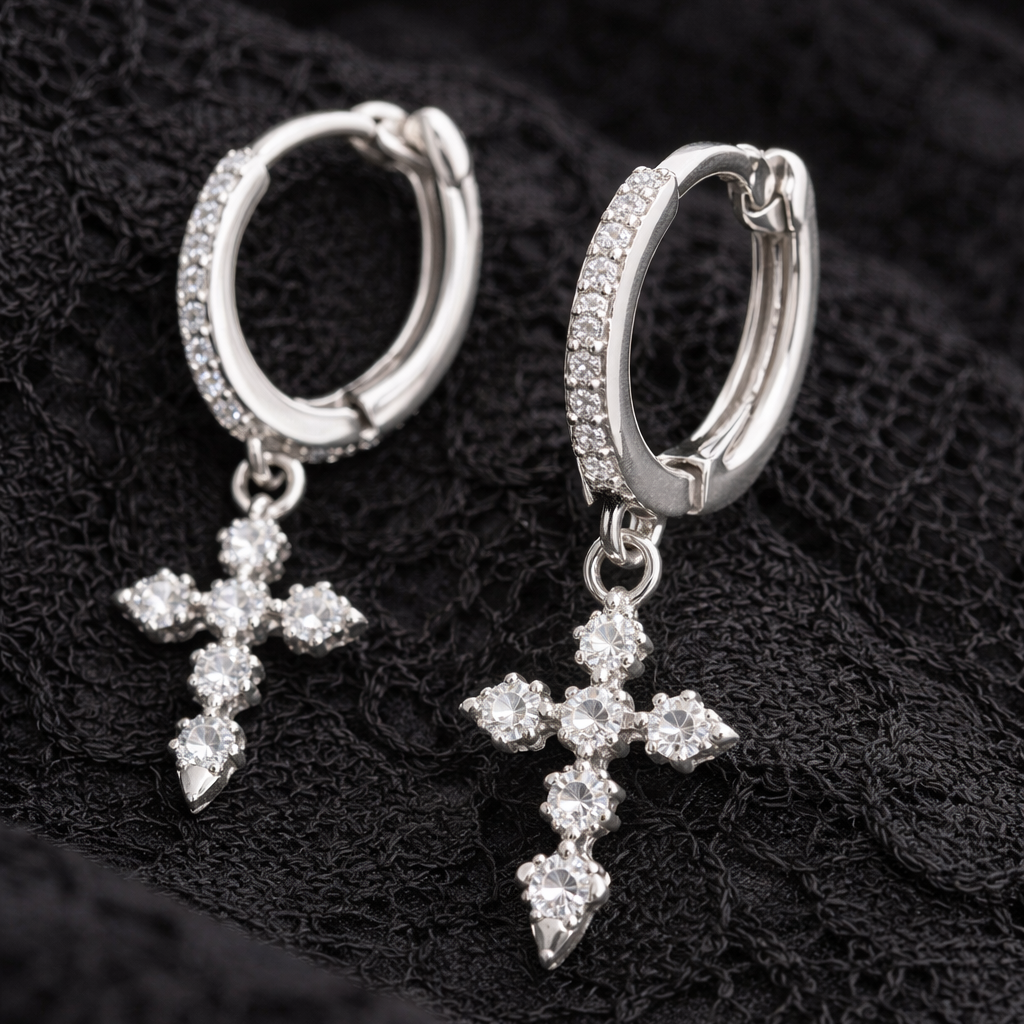 Silver hoop earrings with cross charms on a black textured background