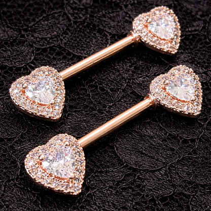 Two rose gold heart-shaped jewelry pieces on a black lace background