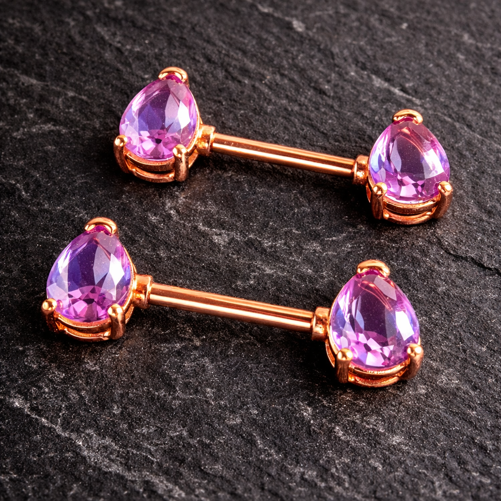 Two rose gold nipple barbells with purple teardrop gemstones on a dark stone background.