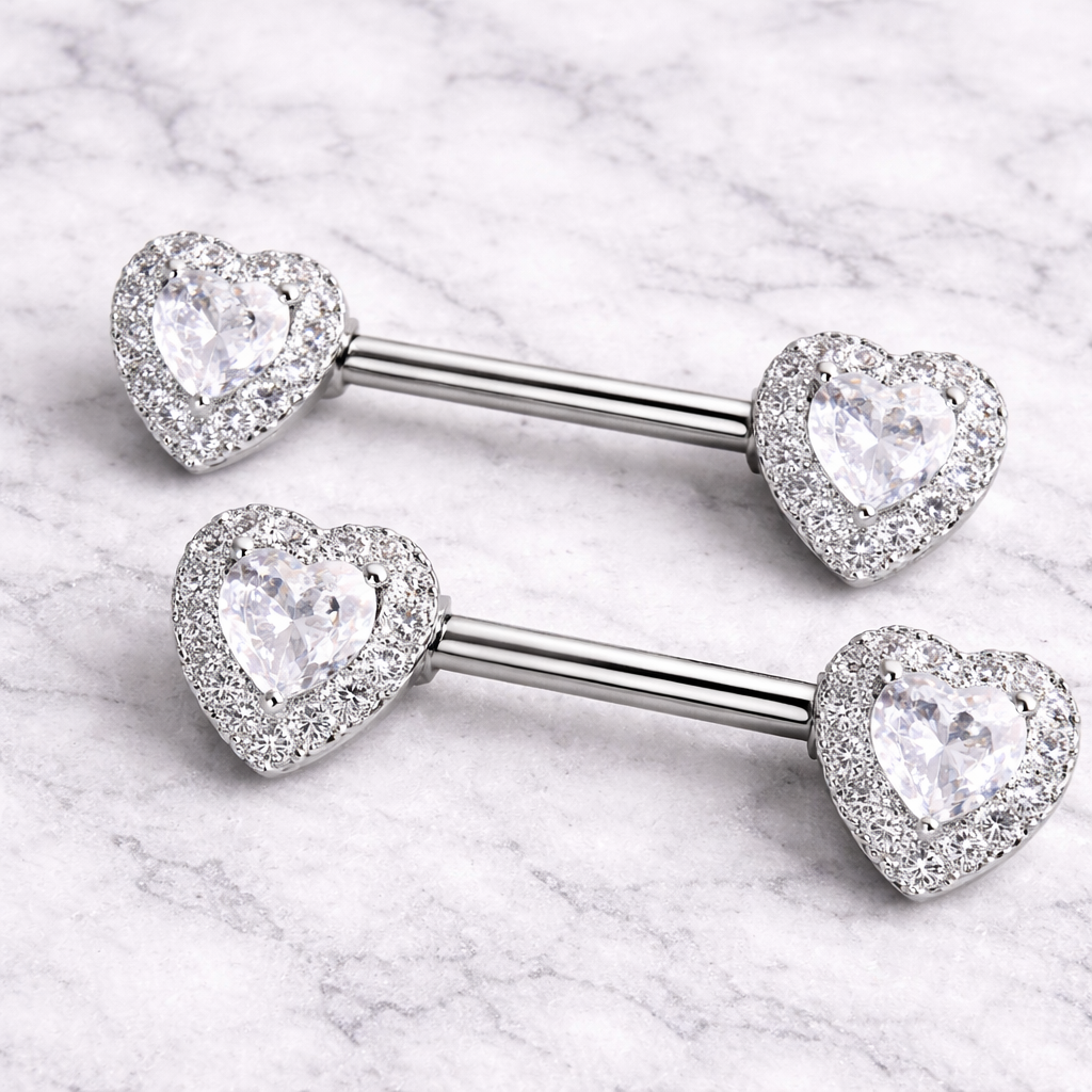 Two silver heart-shaped gemstone nipple barbells on a marble background