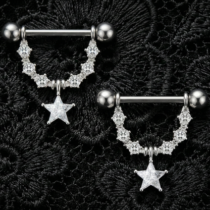 Two silver nipple bars with star charms on a black textured background