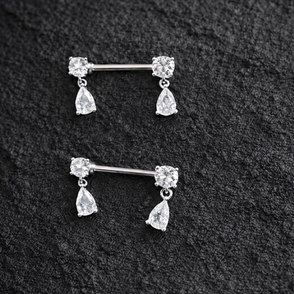 Two silver nipple bars with teardrop-shaped gemstones on a black textured background