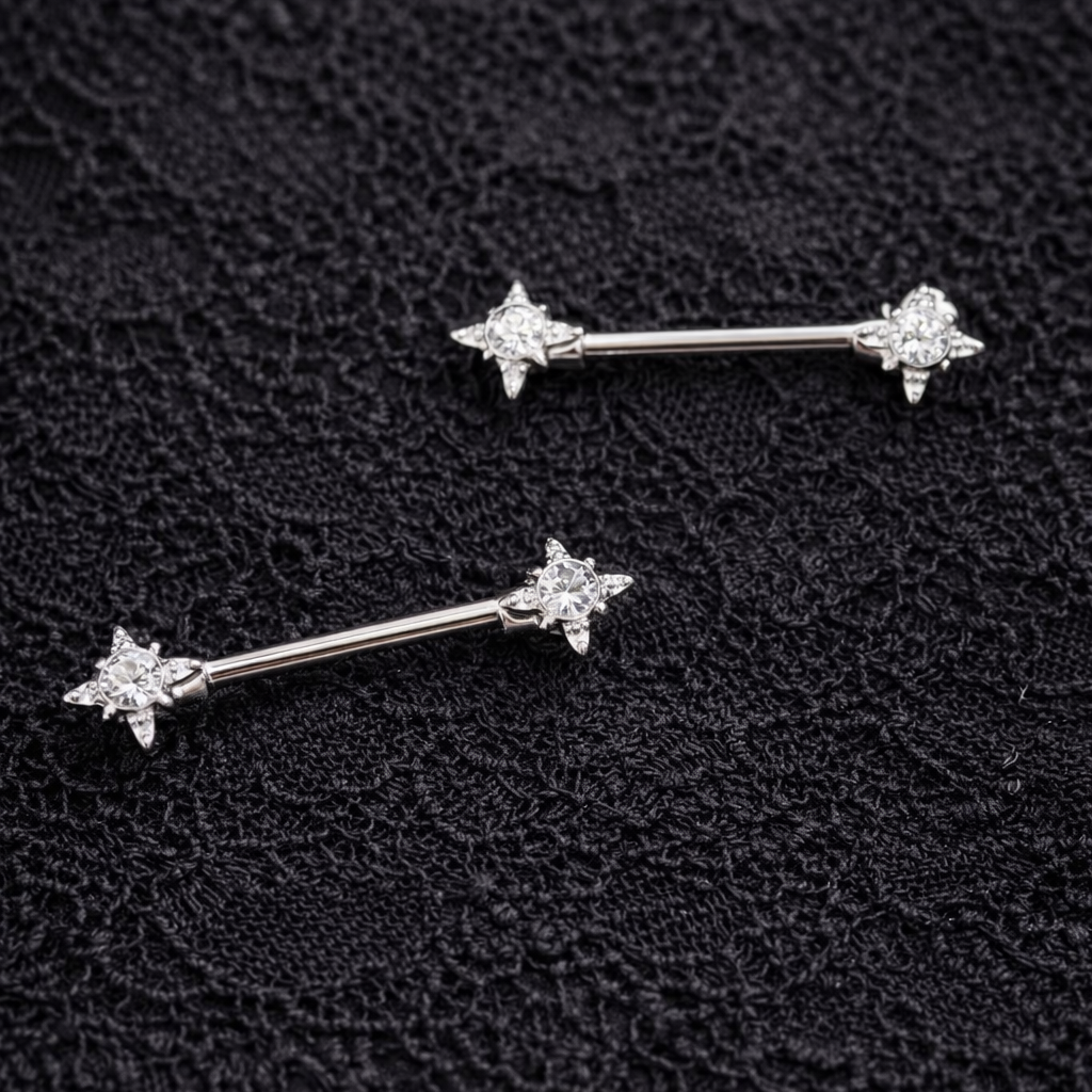 Two silver star-shaped nipple bars on a textured black surface